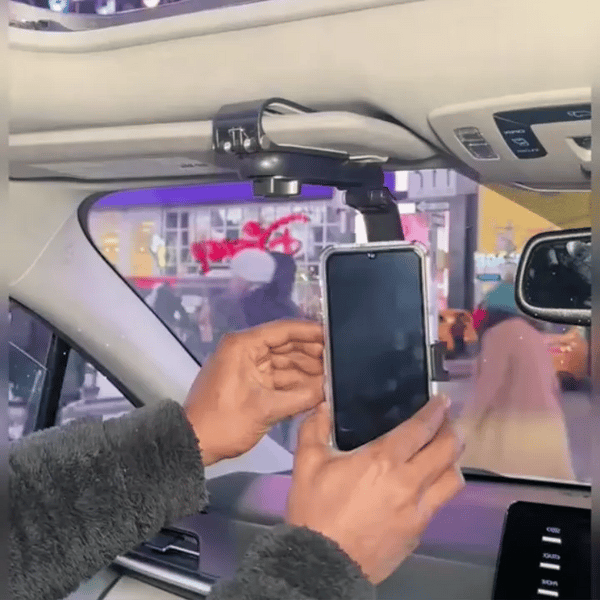 Hombre conduciendo un carro con soporte de celular en la visera